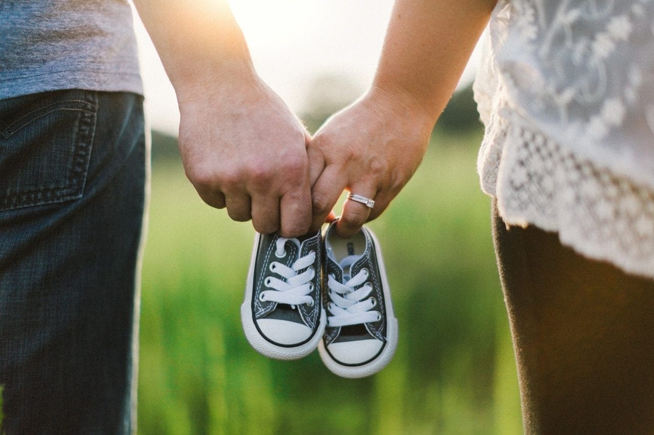 couple holding baby shoes family protection
